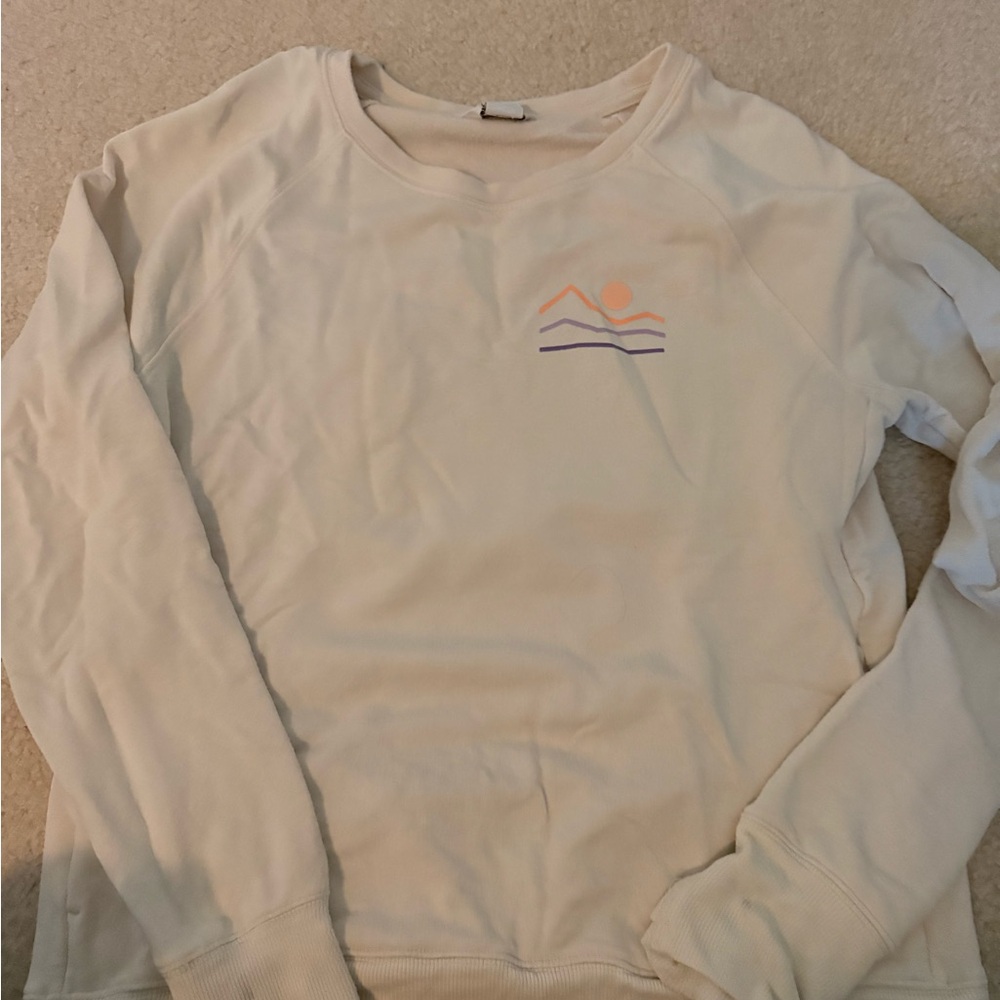 Athleta Girl cream sweatshirt with mountain design.